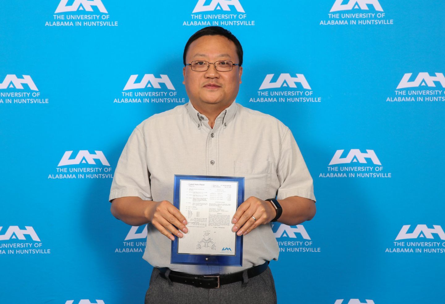 Dr. Gang Wang holding his patent award